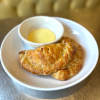 The Buttered Tin Ham, Egg & Cheese Hand Pie on plate with a cup of dipping sauce 
