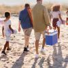 Family going to the beach with coolers and picnic baskets