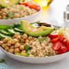 Healthy protein bowl with grains, chickpeas, avocado, tomatoes, and cucumbers