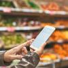 Woman using cell phone while grocery shopping