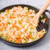 Mirepoix in a cast iron skillet with wooden spoon